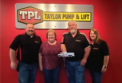 A group of people standing in front of a sign.