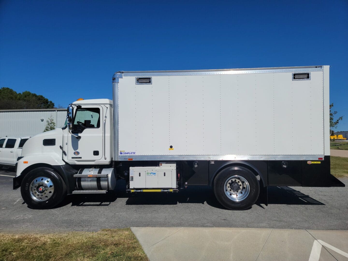 A white truck parked on the side of a road.