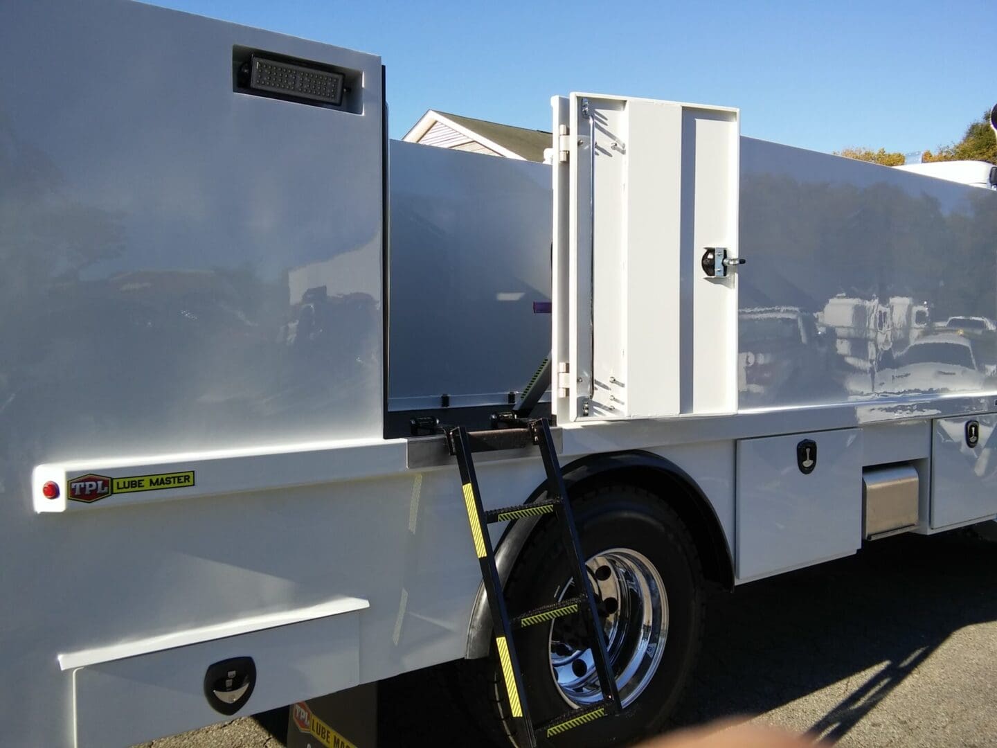 A white truck with its door open and the handle on it.