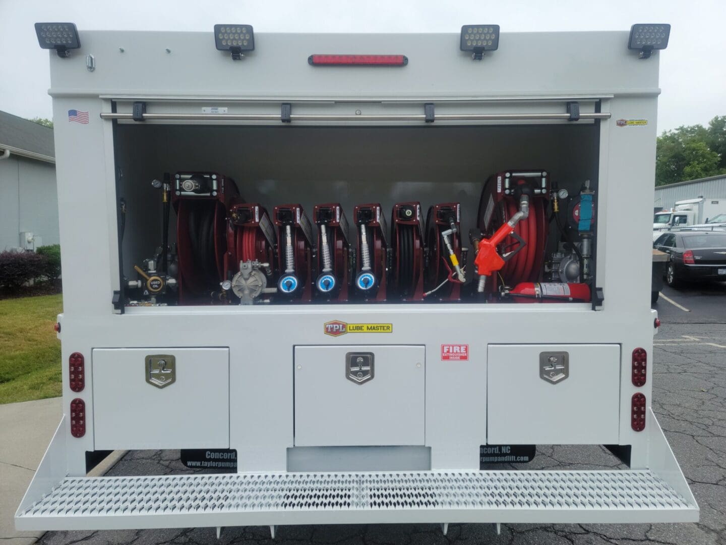 A fire truck with the doors open and its equipment in it.
