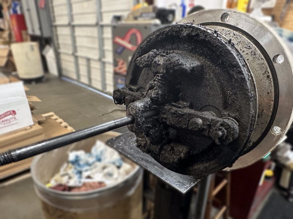 Dirty interior of Graco grease pump, displaying debris clogging pump